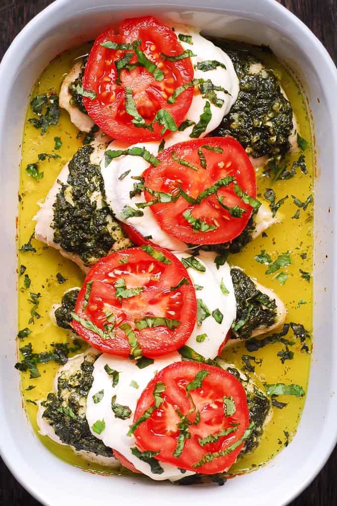 Basil Pesto Tomato Mozzarella Chicken Bake in a white casserole dish.