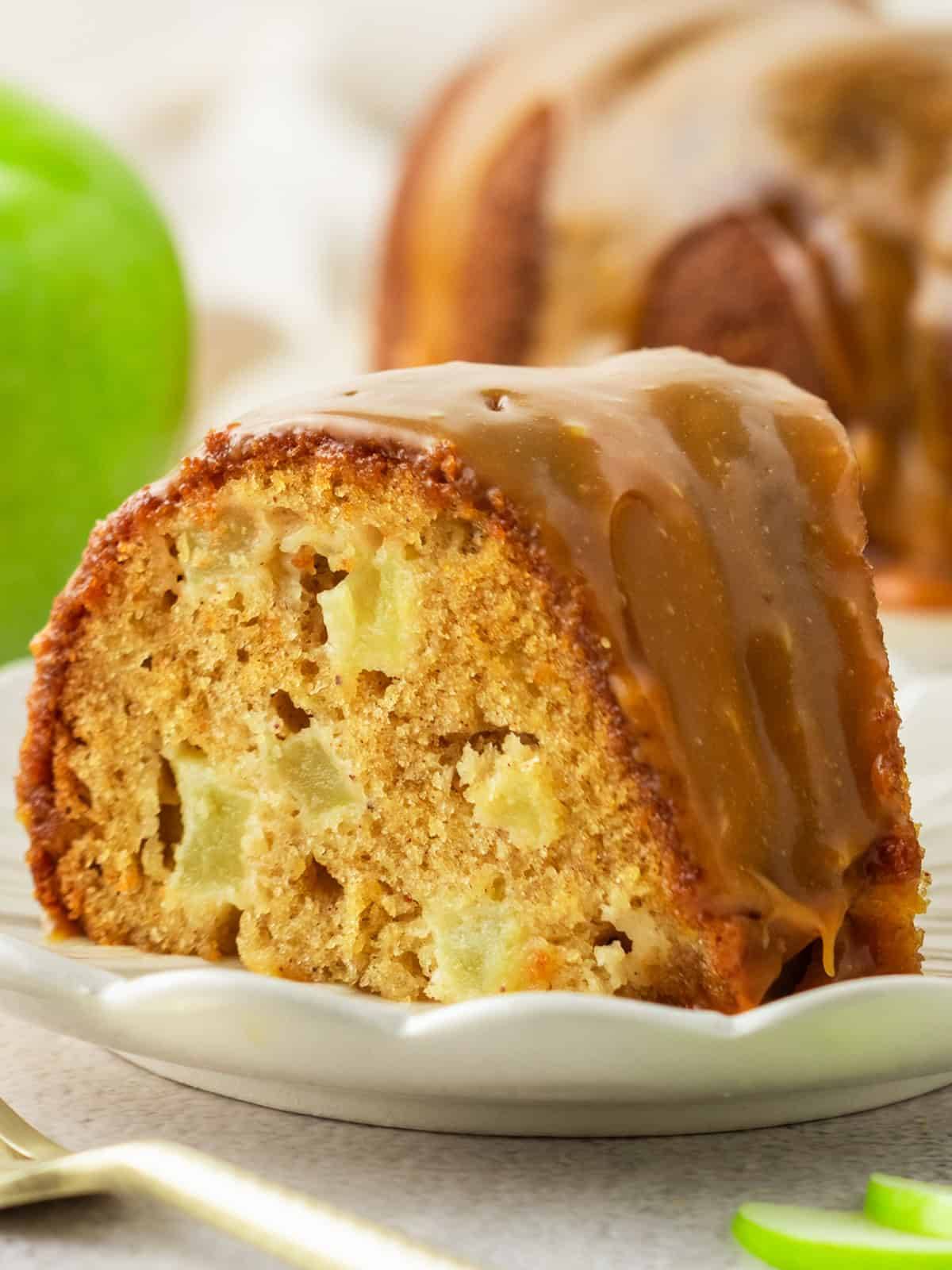 A slice of Apple Caramel Bundt Cake on a white plate.