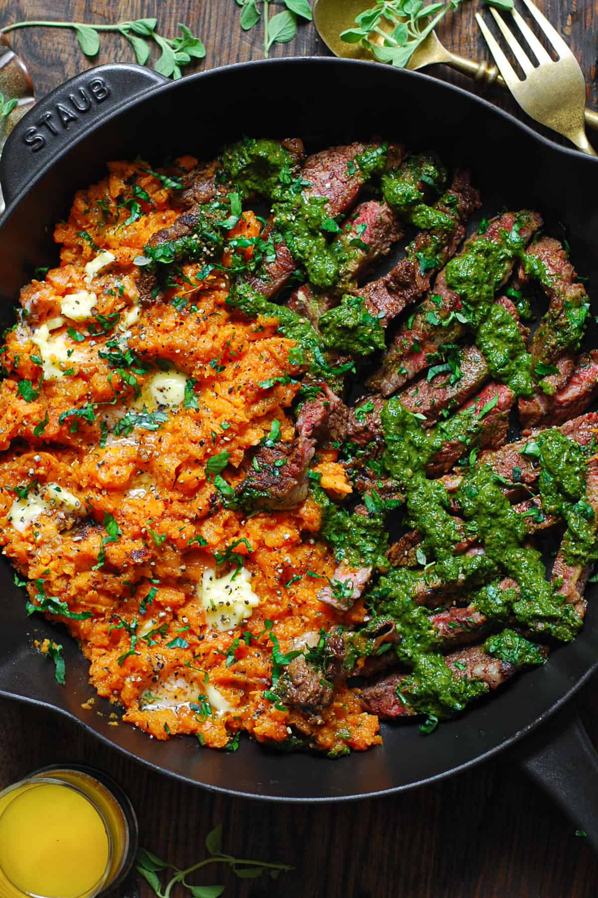 Pan-Seared Flank Steak with Spinach Pesto and Buttery Sweet Potatoes - in a cast iron pan.