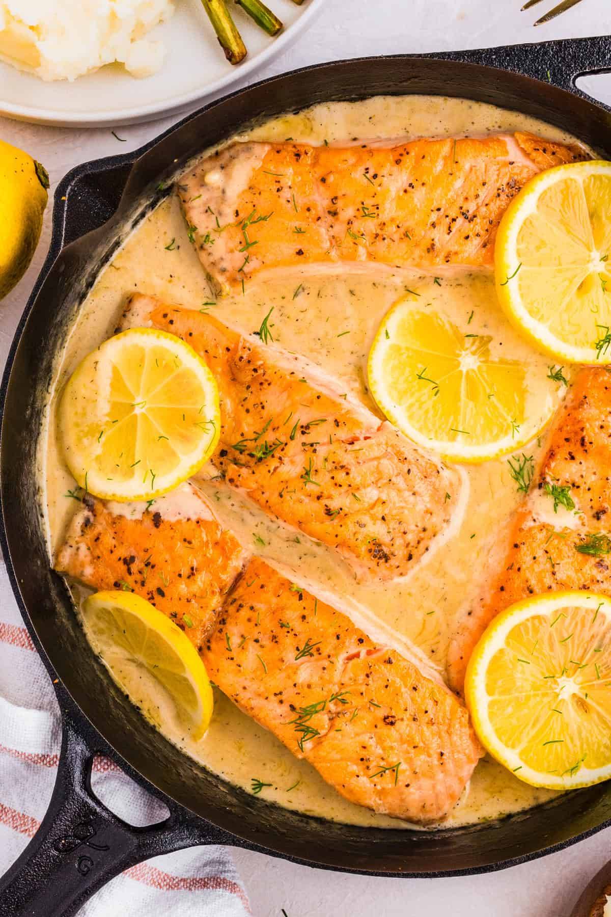 Salmon with Lemon Dill Sauce in a cast iron skillet.