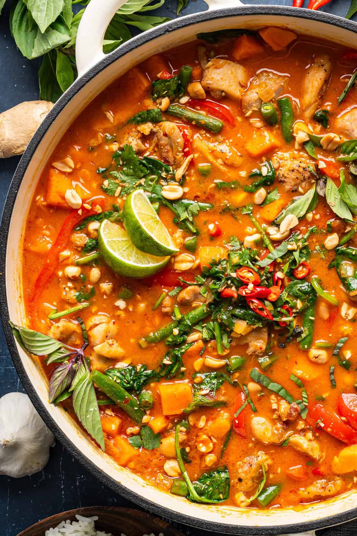 Thai Coconut Chicken Curry with Sweet Potatoes and Green Beans in a white pot.