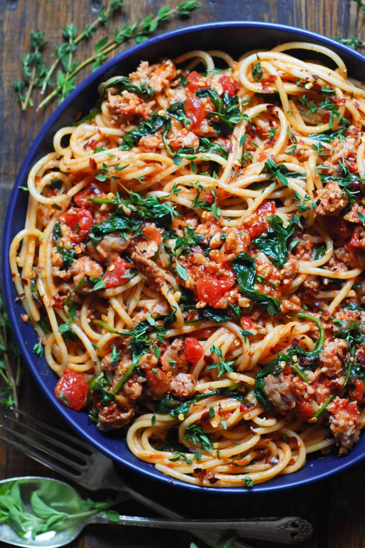 Italian Sausage Spaghetti with Spinach in a blue bowl.