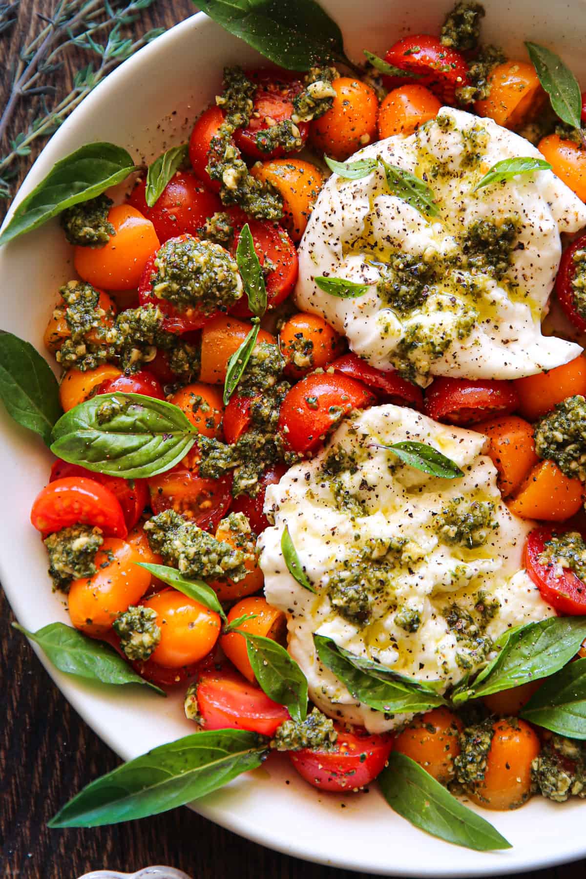 Spring ​Tomato Burrata Salad​ with Fresh Homemade Basil Pesto in a bowl.