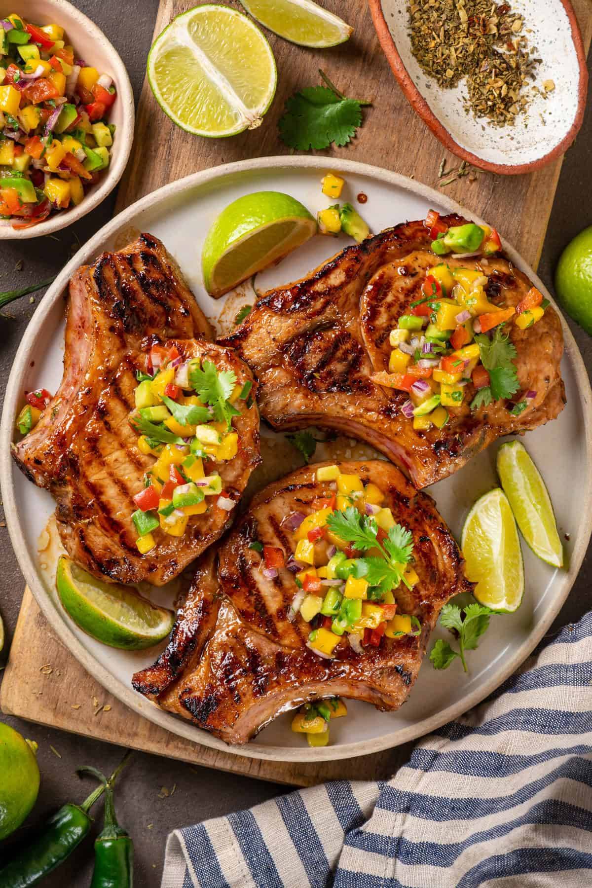 Grilled Marinated Pork Chops and Mango Salsa on a white plate.