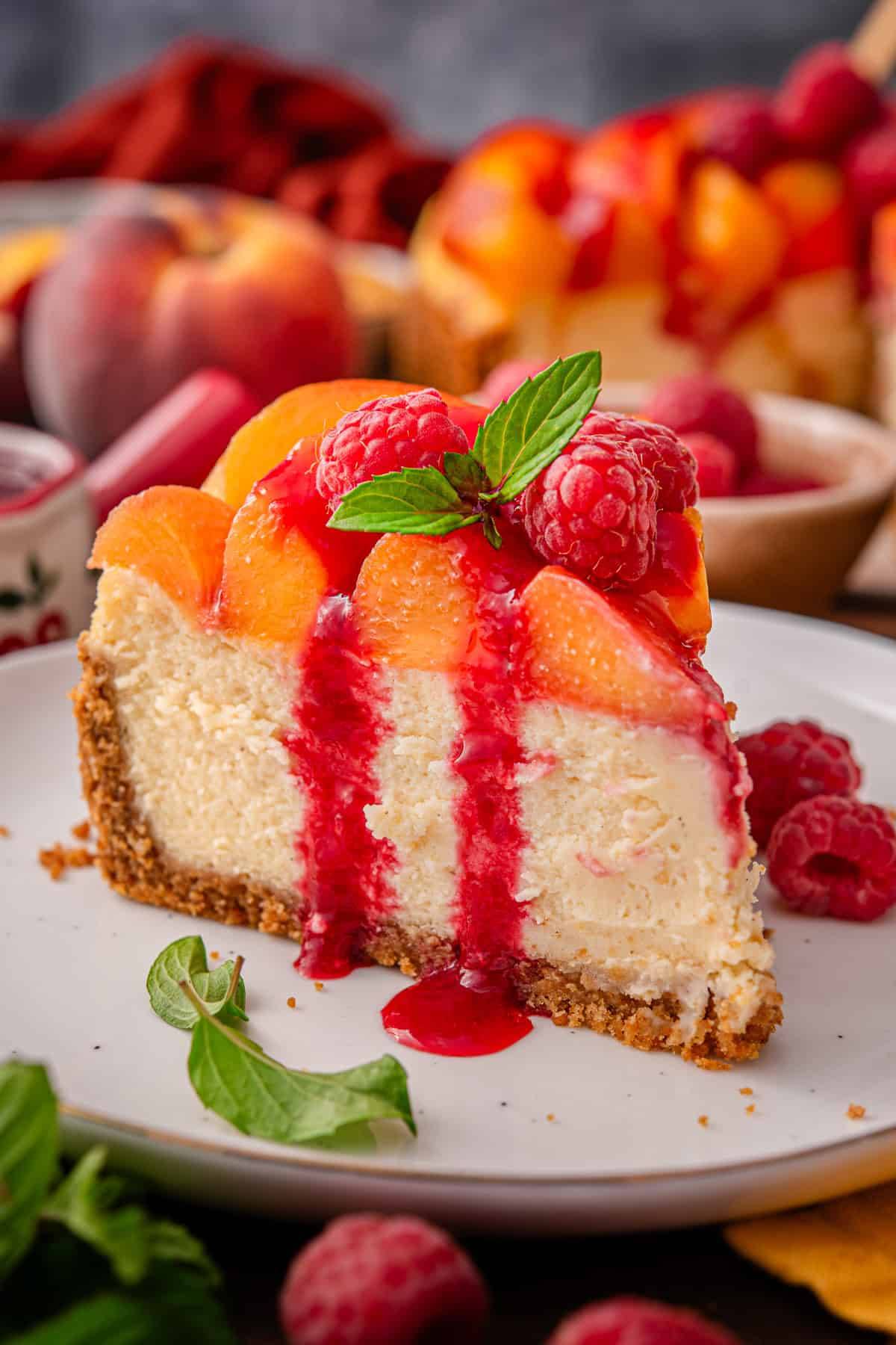 Raspberry Peach Cheesecake slice on a white plate.