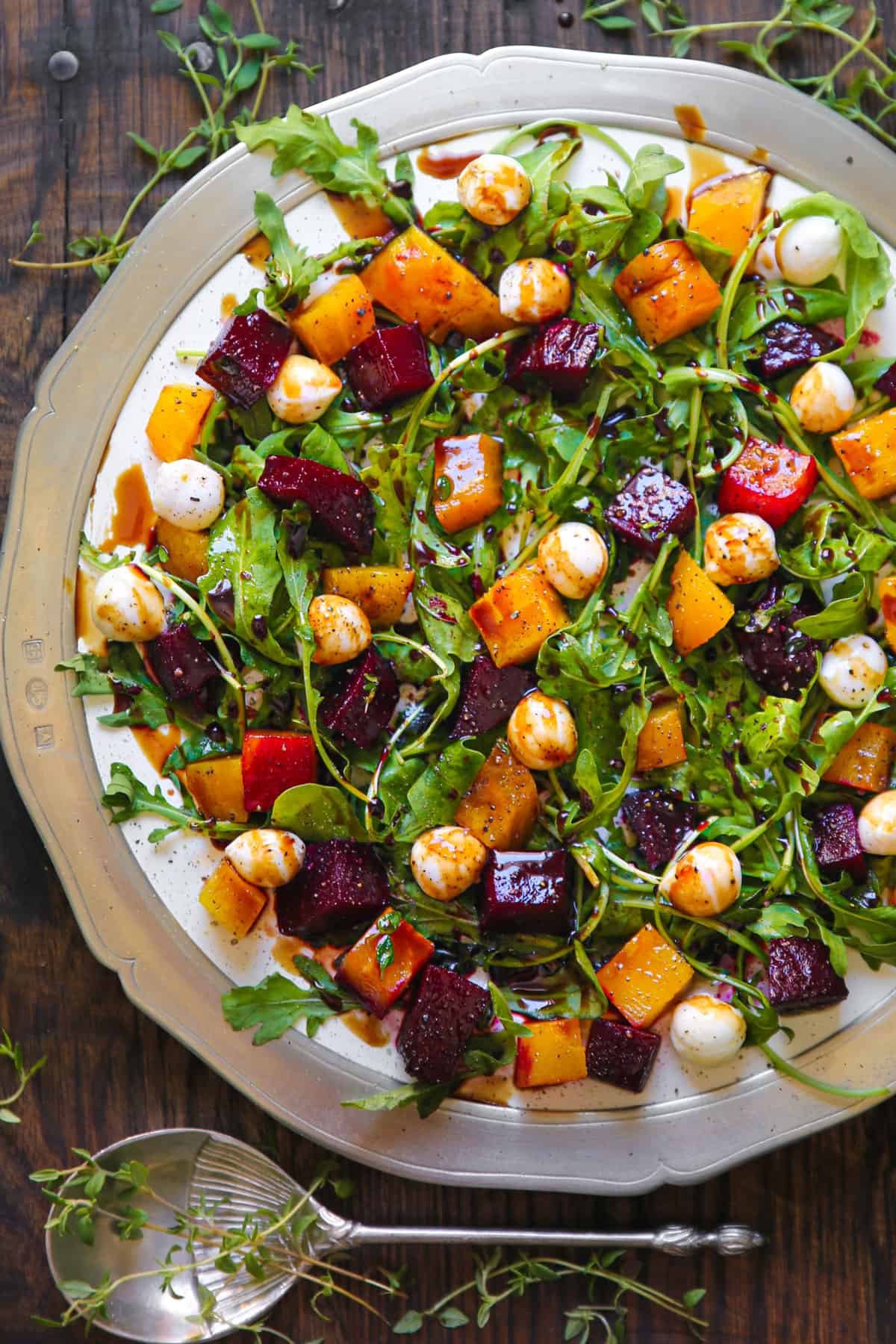Beet and Mozzarella Salad with Arugula and Balsamic Dressing on a white plate.
