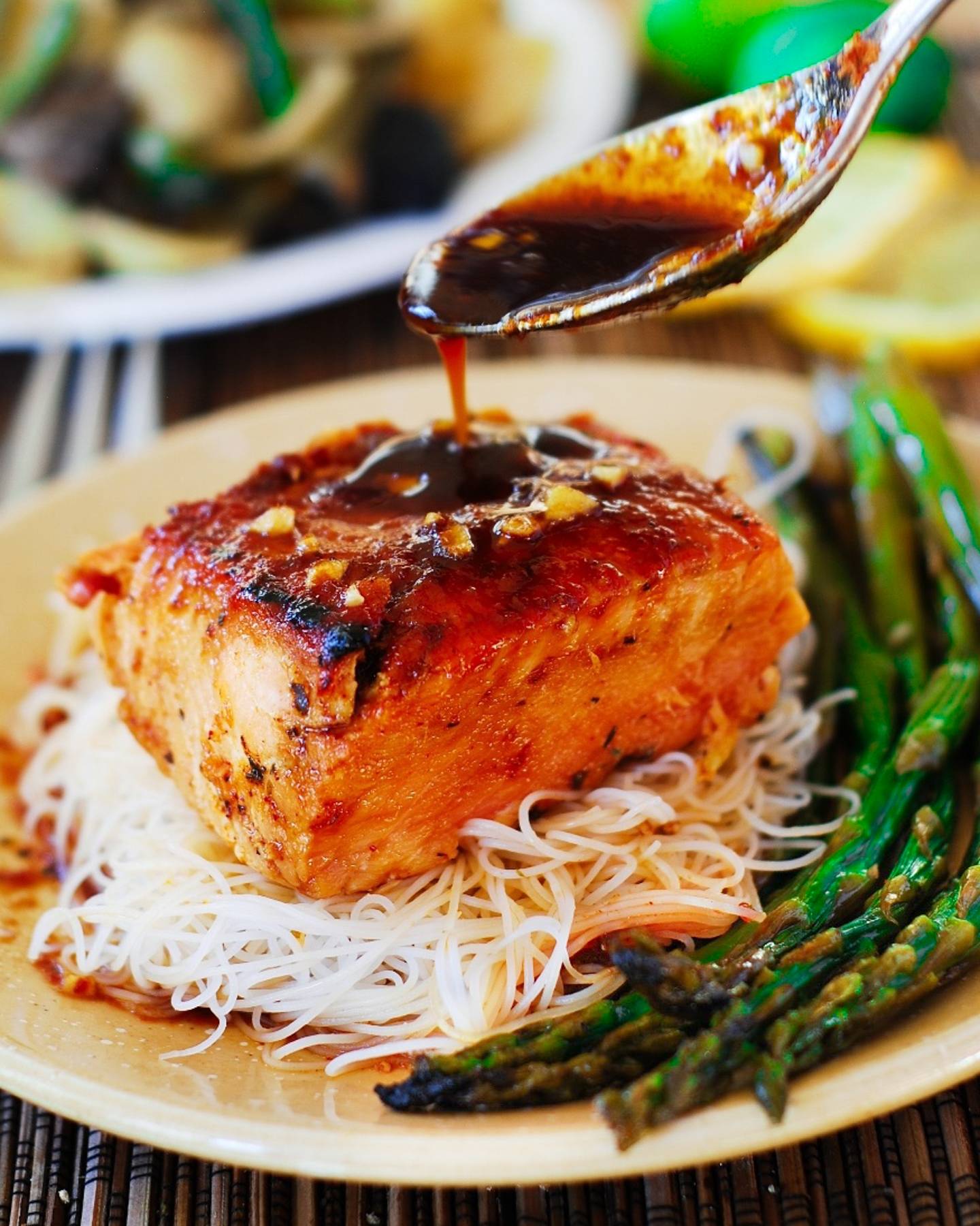 Honey-Sesame Asian Salmon with Rice Noodles and Asparagus on a plate.