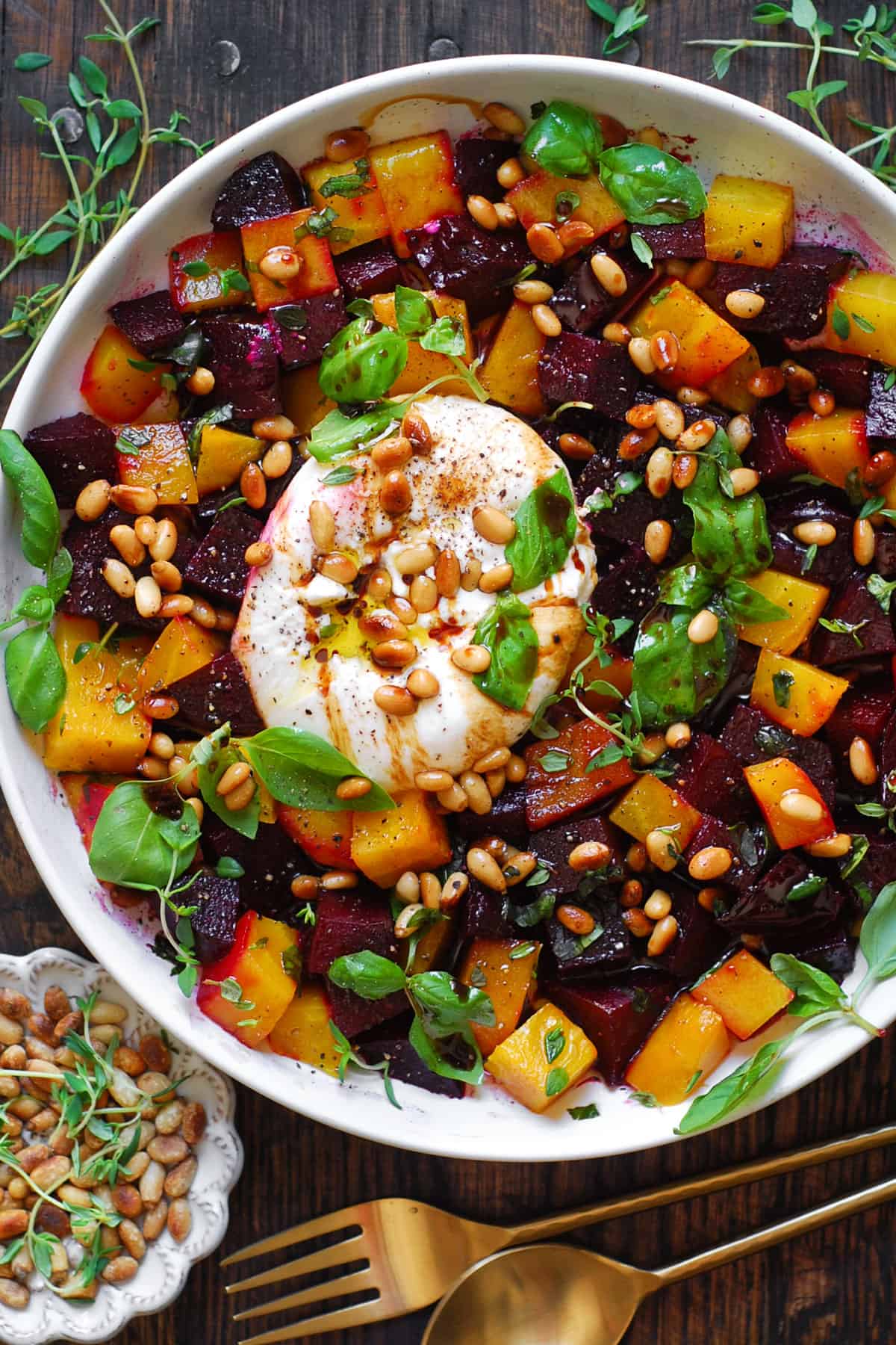 Beet and Burrata Salad with Pine Nuts and Balsamic Dressing in a white bowl.