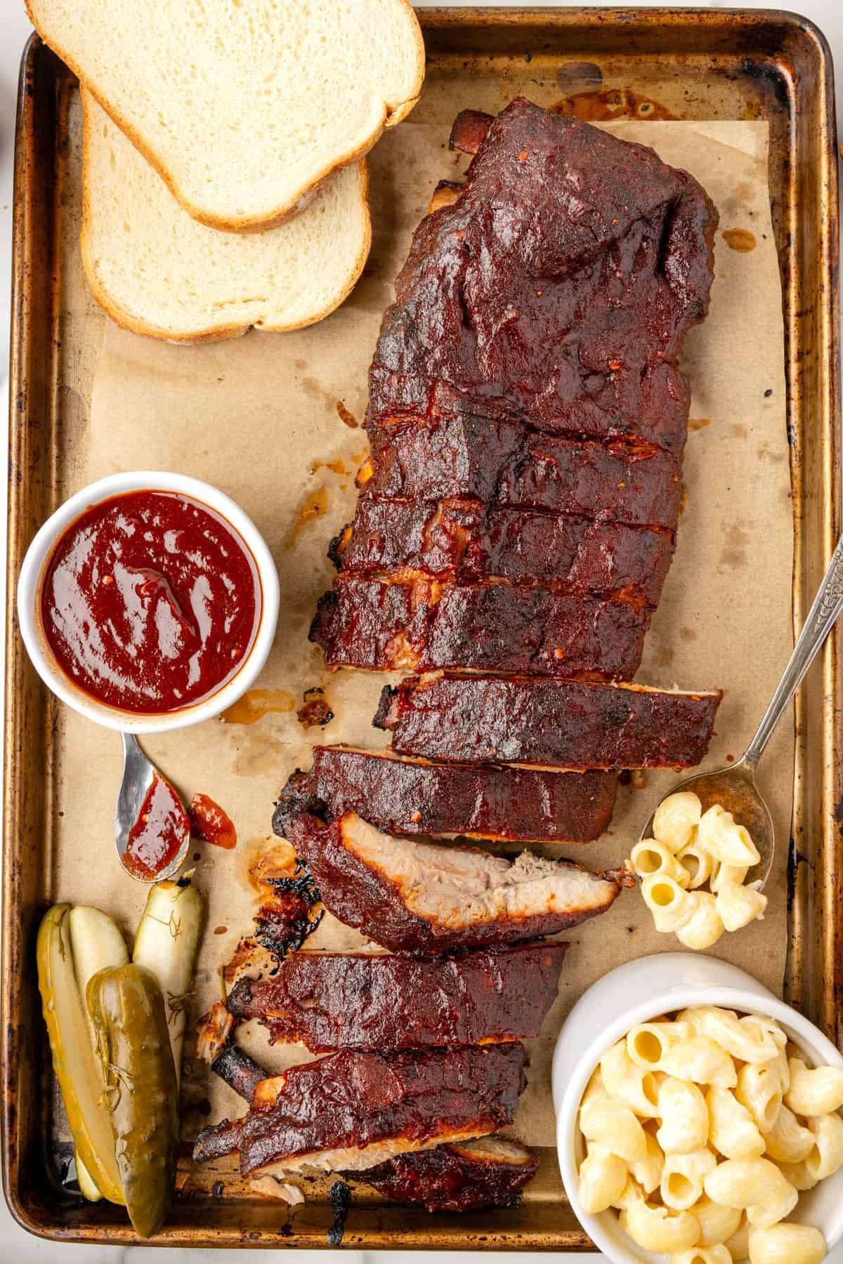 Oven Baked Ribs with Homemade Kansas City BBQ Sauce on a sheet pan.