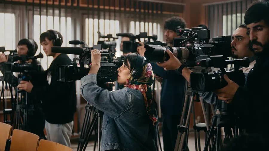 Naru (Shahrbanoo Sadat) films alongside a row of male camera operators in No Good Men (2026).