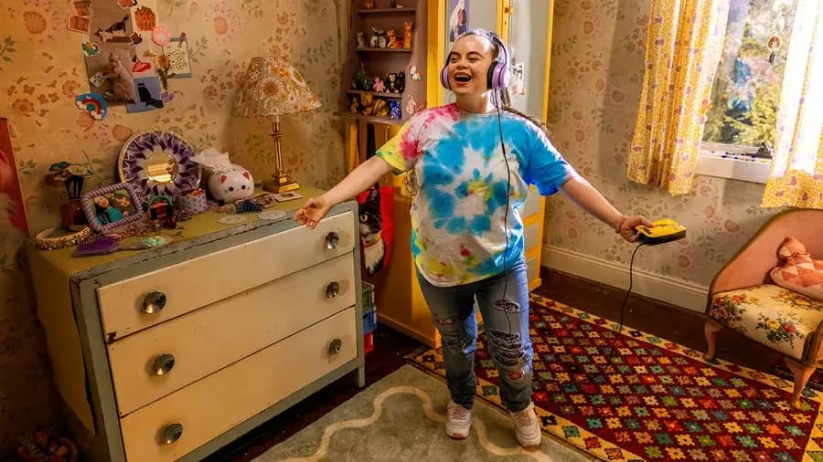 Olivia Hargroder as Sonja sings along to music on a CD player in her colourful bedroom in Boss Cat (2026)