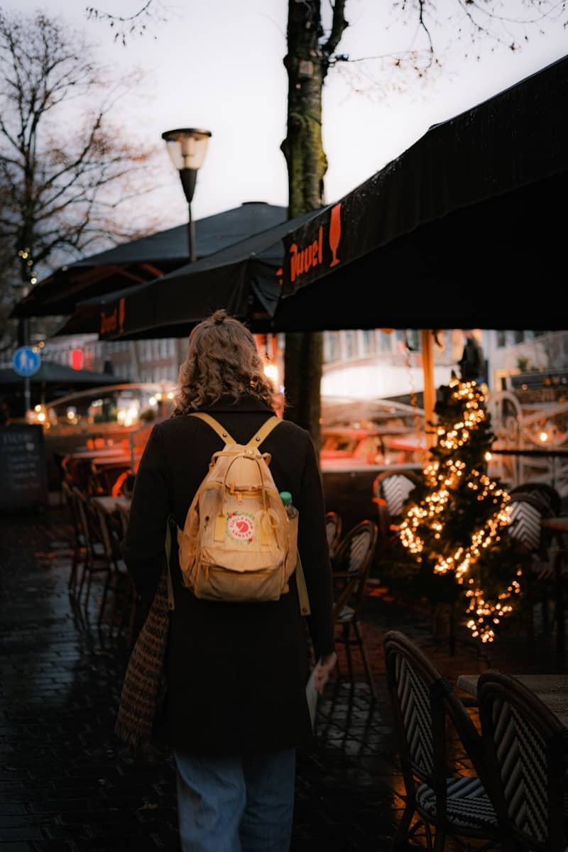 A person with a backpack walking down a street