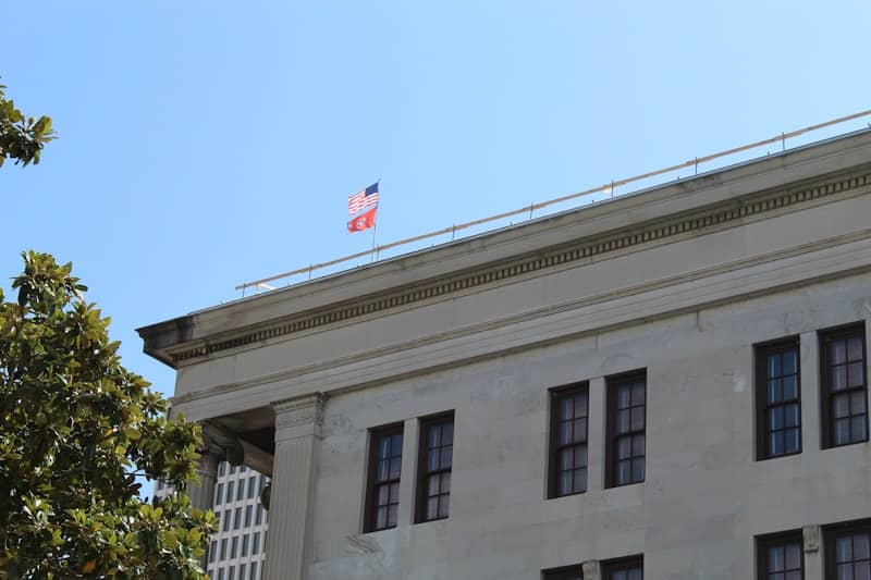 A flag waves atop an old building.