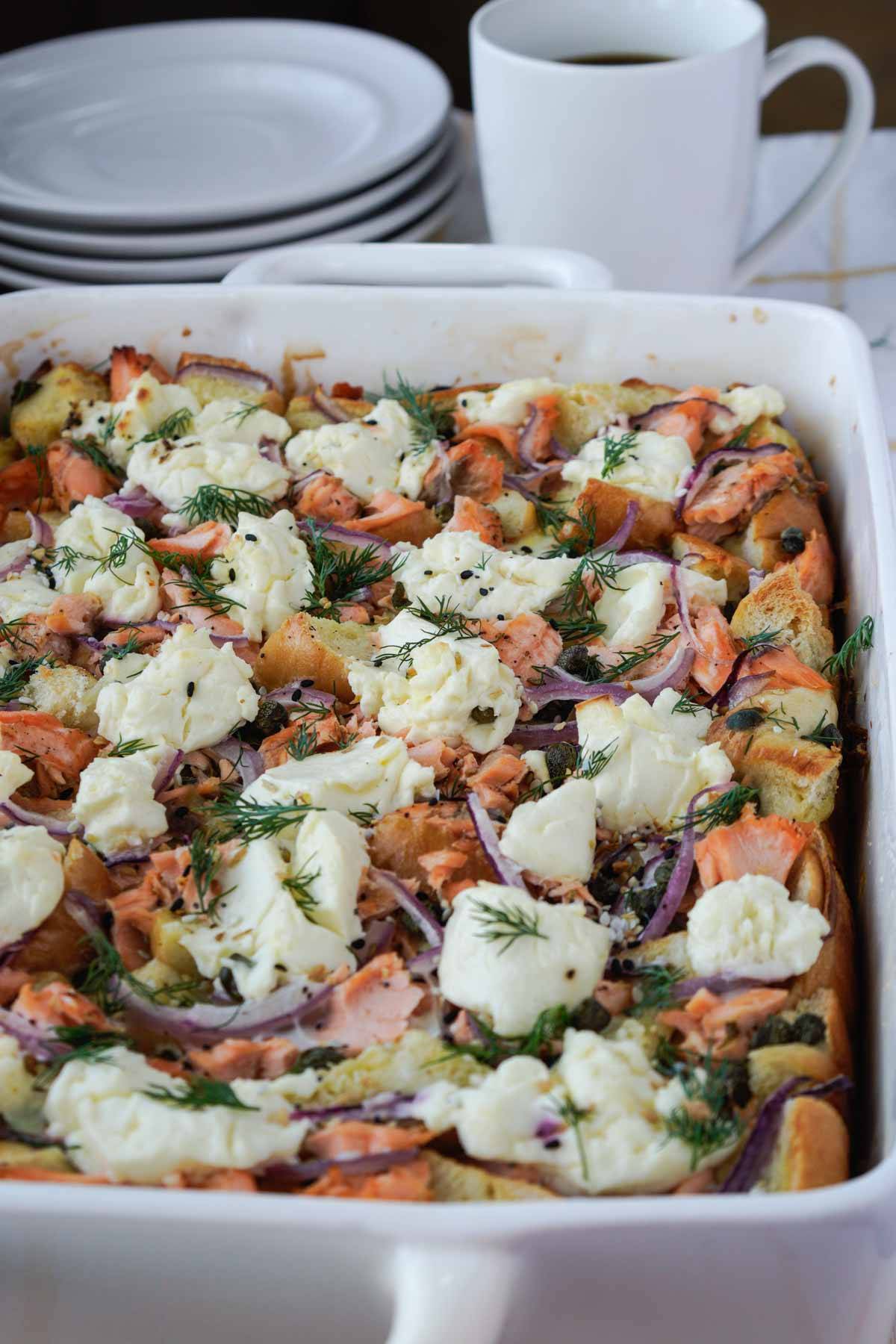 Bagel strata with salmon and cream cheese in a white casserole dish