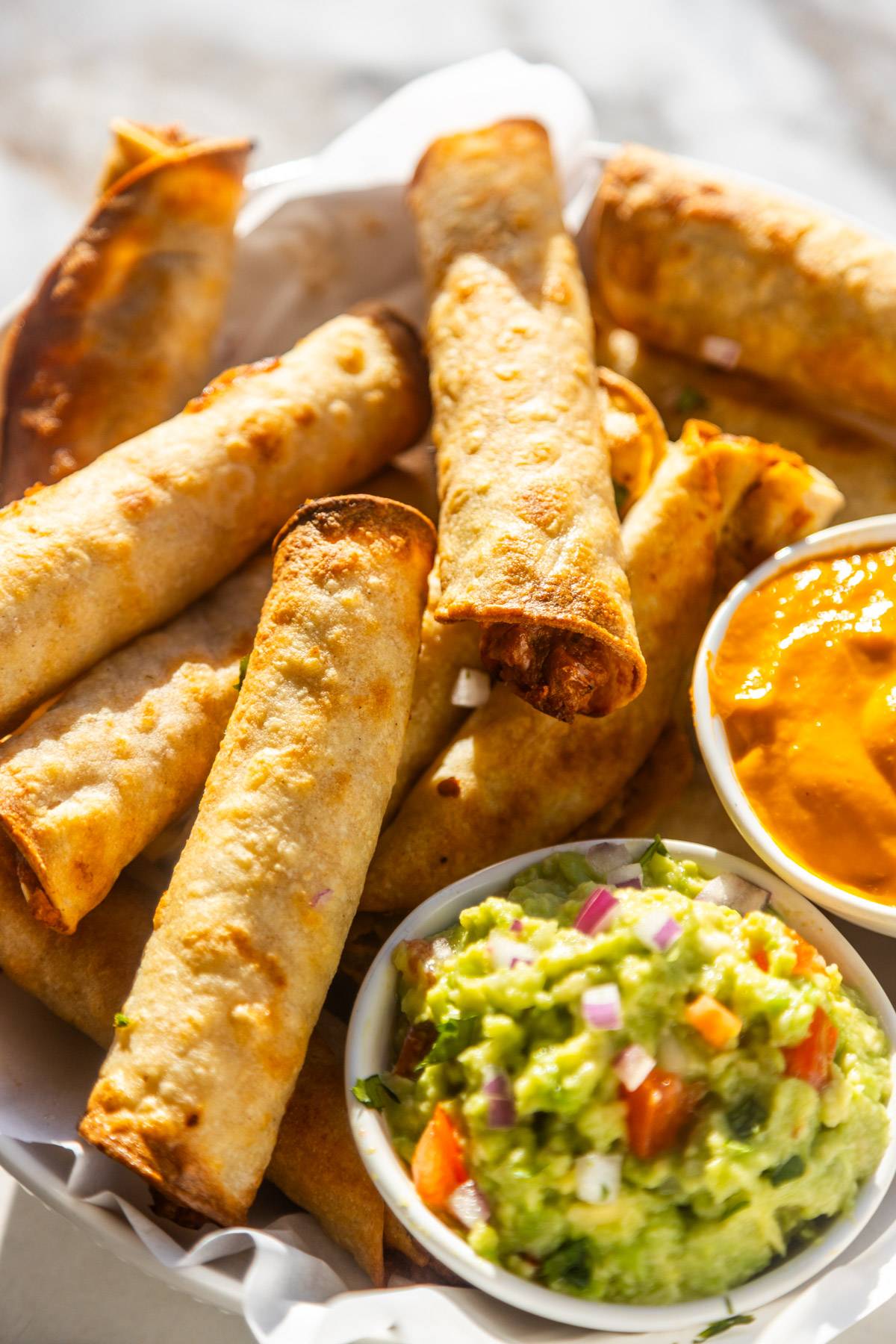 Crispy vegan taquitos on a plate.