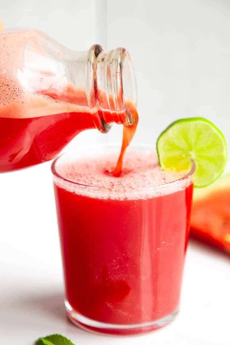 Watermelon juice pouring into a glass.