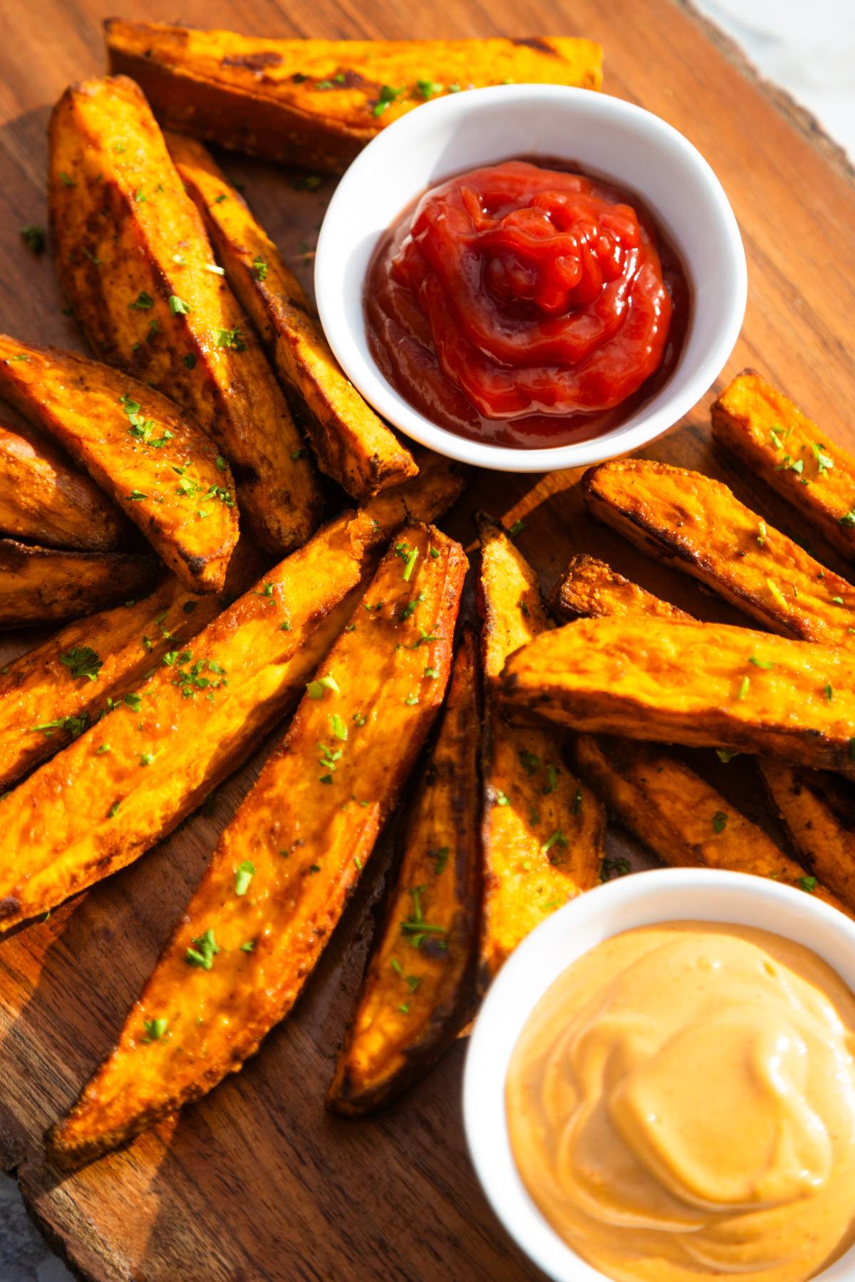 Air fryer sweet potato wedges with ketchup on the side.