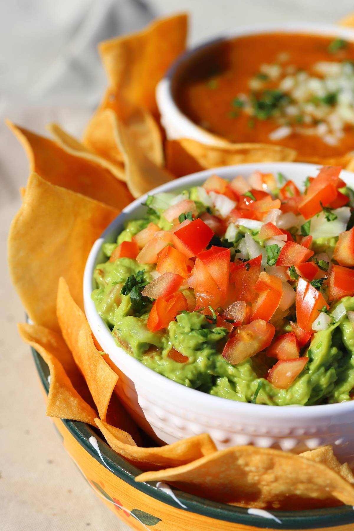 Guacamole in a bowl with chips on the side.