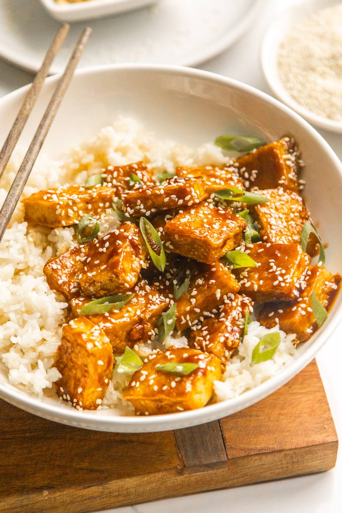 Sticky Maple Glazed Tofu in a bowl with rice and chopsticks.