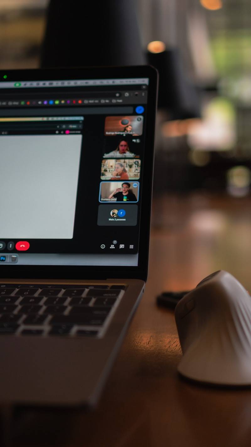 Laptop screen showing a video conference with multiple participants.