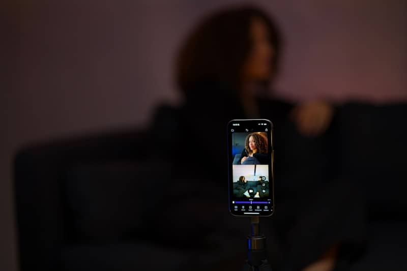 Smartphone recording a woman in a dimly lit room.