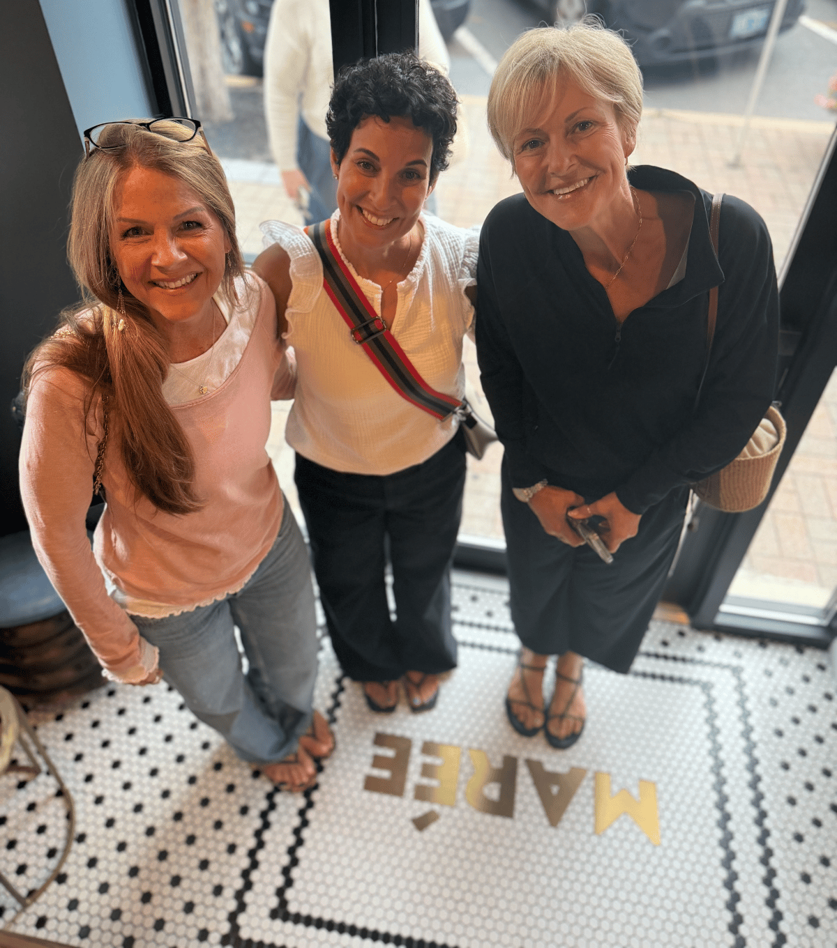 Three guests standing on the tile floor at Marée's entrance