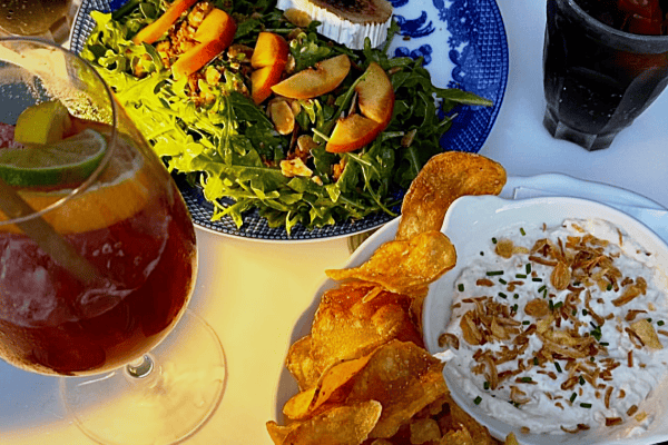 A table at Marée set with greens, chips and onion dip and a glass of sangria