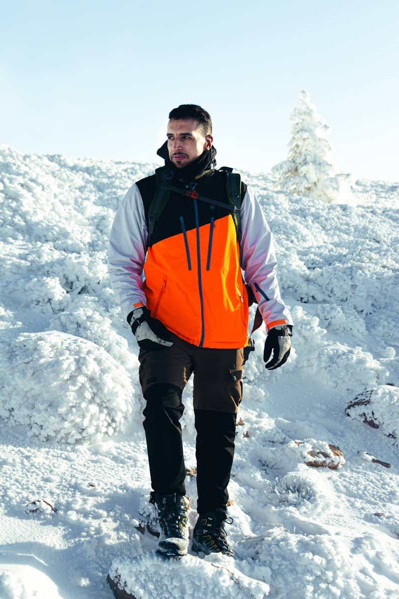 Man in winter gear walking on snowy mountain
