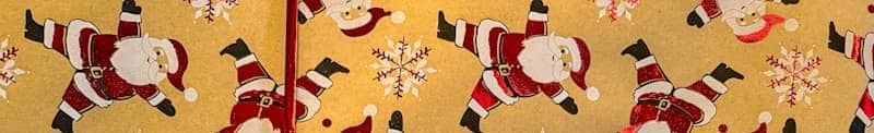 Christmas gift wrapped in santa claus paper with red ribbon.