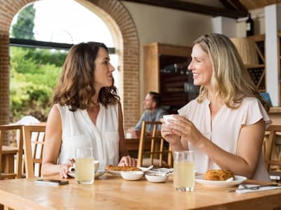 Two friends in midlife having lunch together.