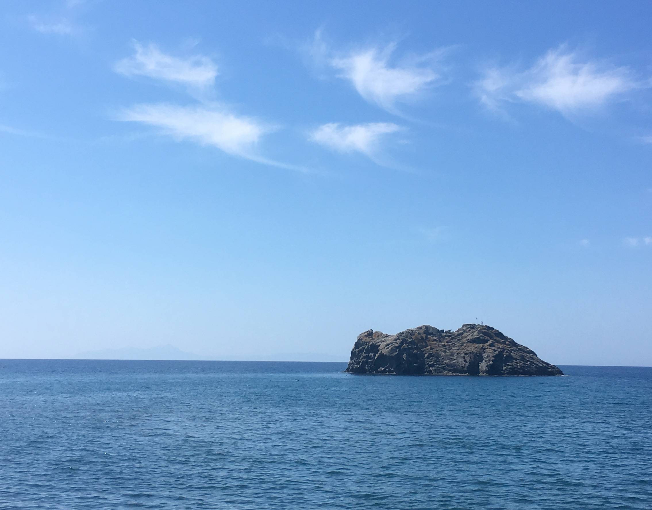 Beautiful stone island in the blue sea off the shore of Lesvos, Greece