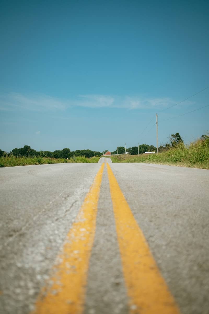 Double yellow lines on a long, straight road.