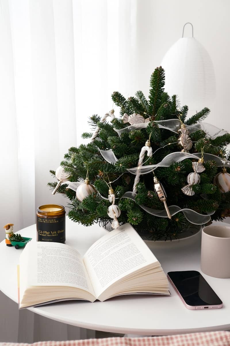 A table with a christmas tree and an open book