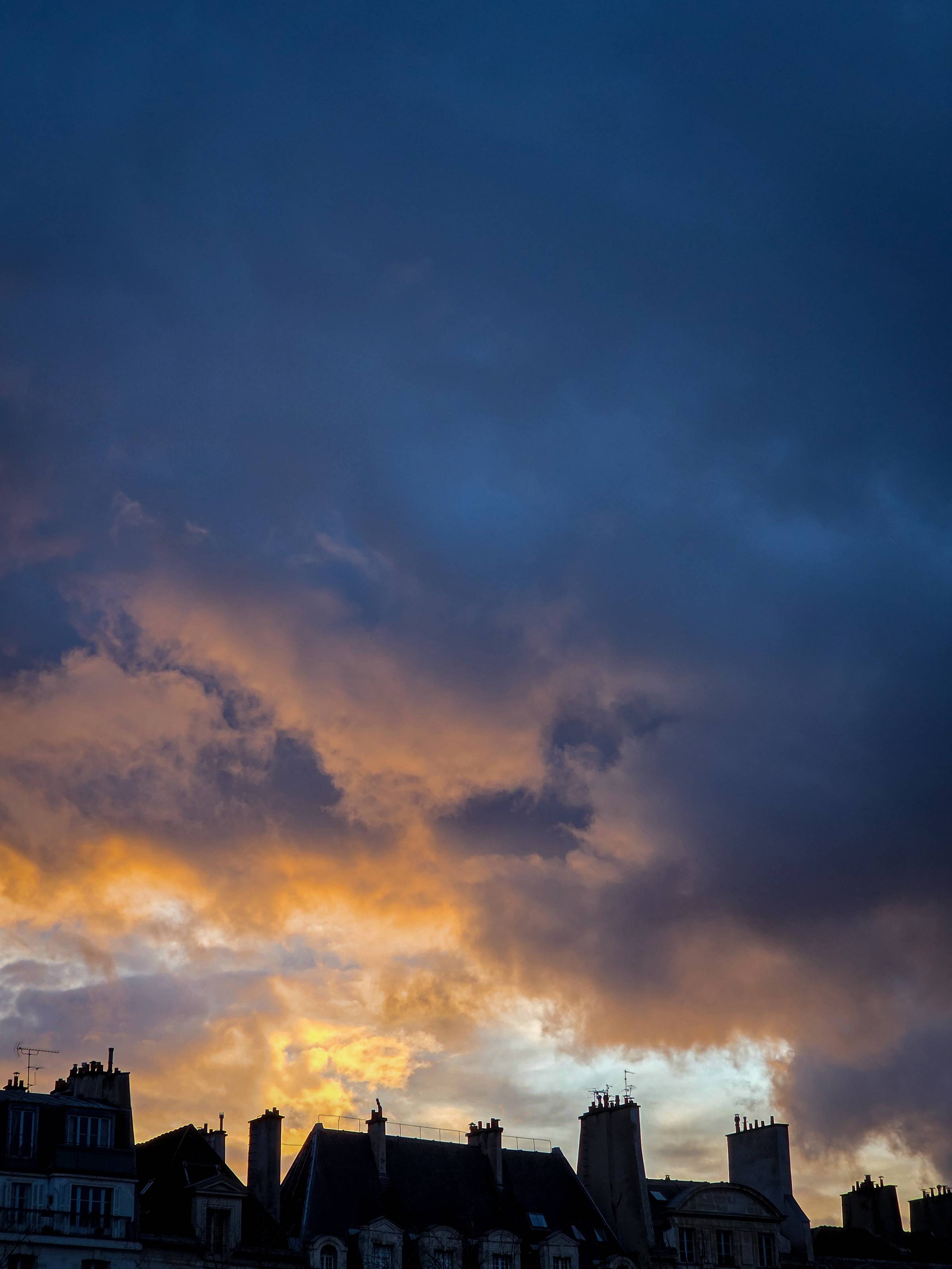 Golden sunset illuminating dramatic winter clouds over Parisian rooftops ©Stephanie Dosch | theViatrix Luxury Travel