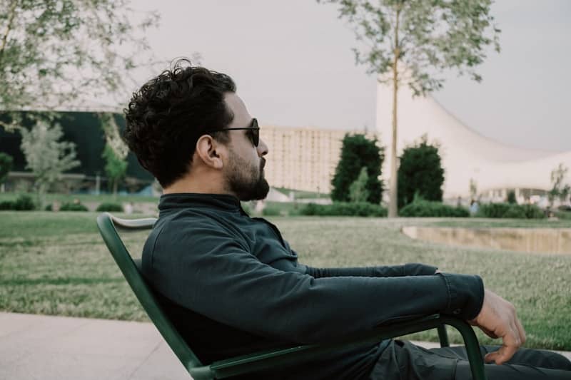 Man relaxes in a chair, enjoying the outdoors.