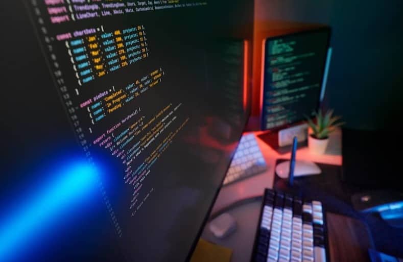 Coding code on multiple computer screens.