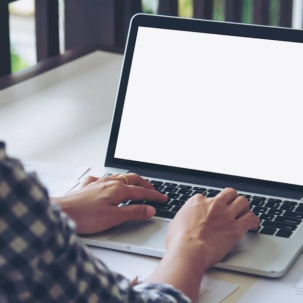 Person sits at a blank computer screen ready to start writing.
