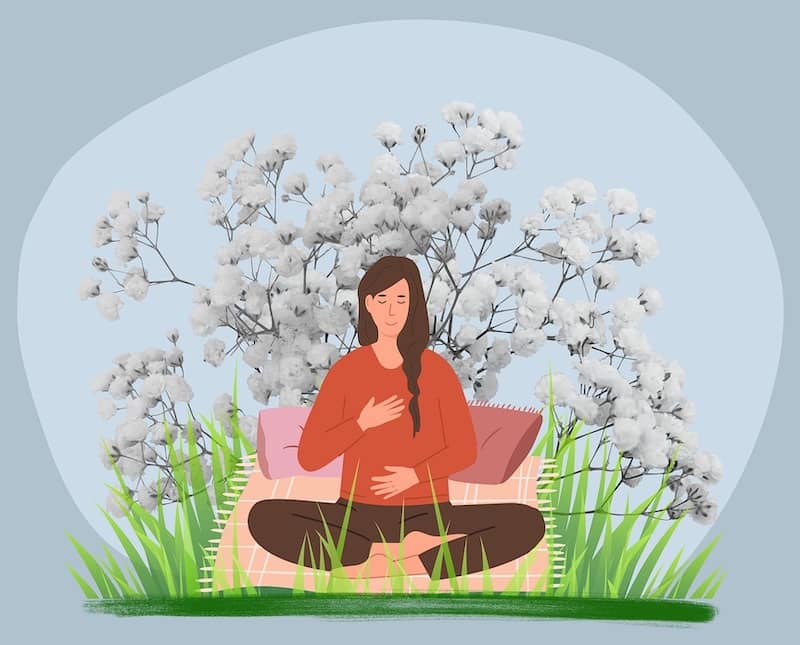 Woman sits in nature calm and relaxed.