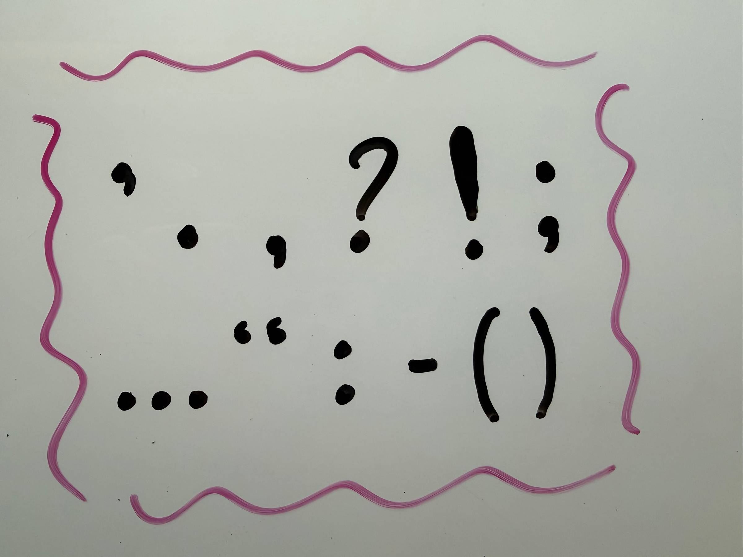 Various punctuation marks written on a whiteboard.
