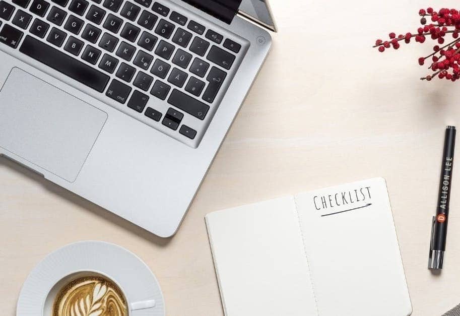 Clean desk workspace with laptop, notebook, and coffee cup
