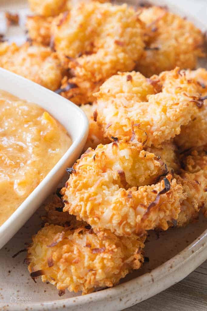 air fryer coconut shrimp next to dipping sauce