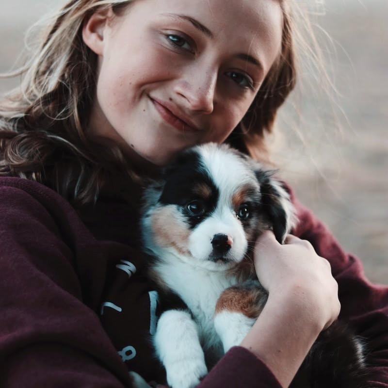 smiling woman hugging puppy