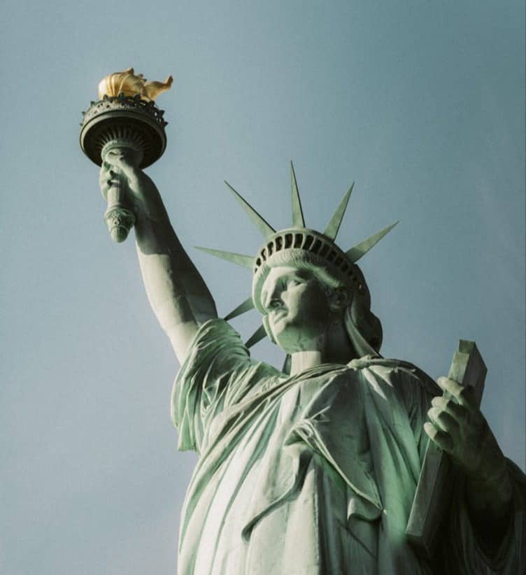 The statue of liberty is holding a bird in its hand