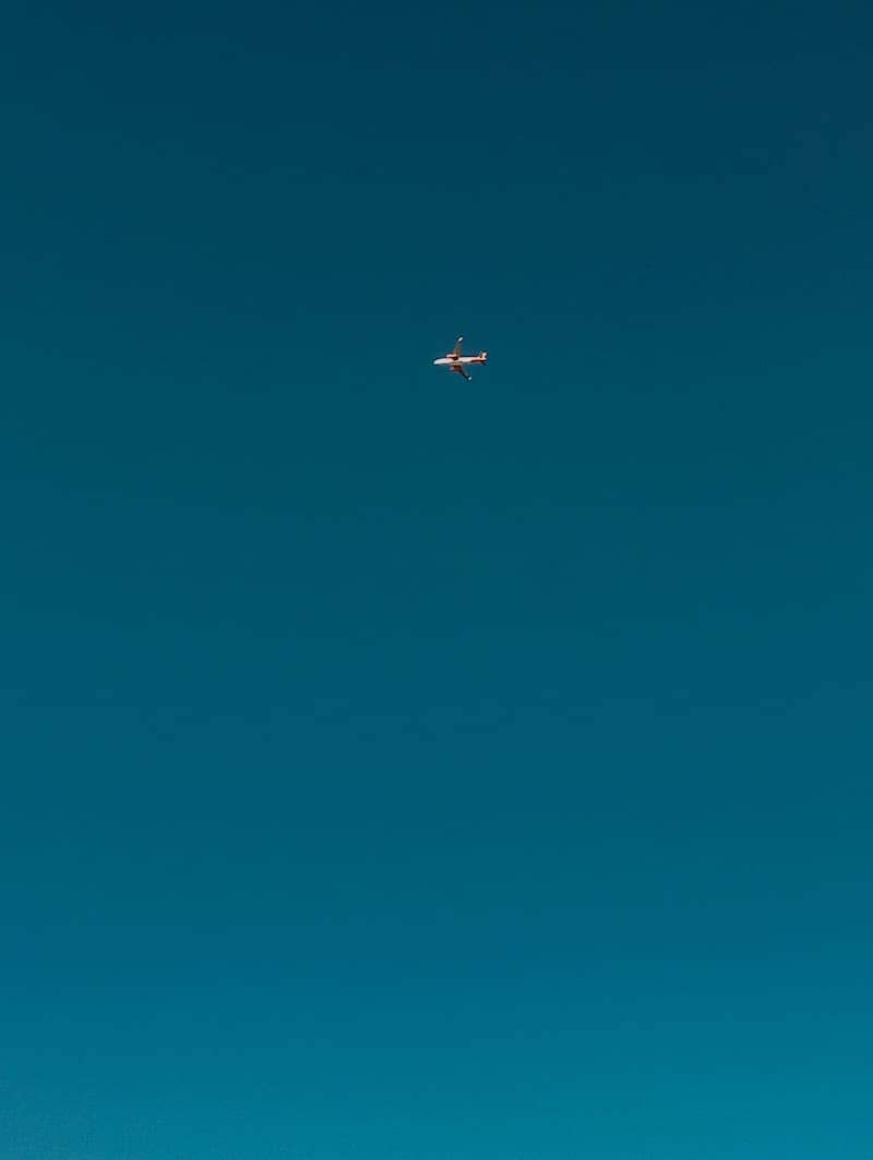 A small helicopter flies in the clear blue sky.