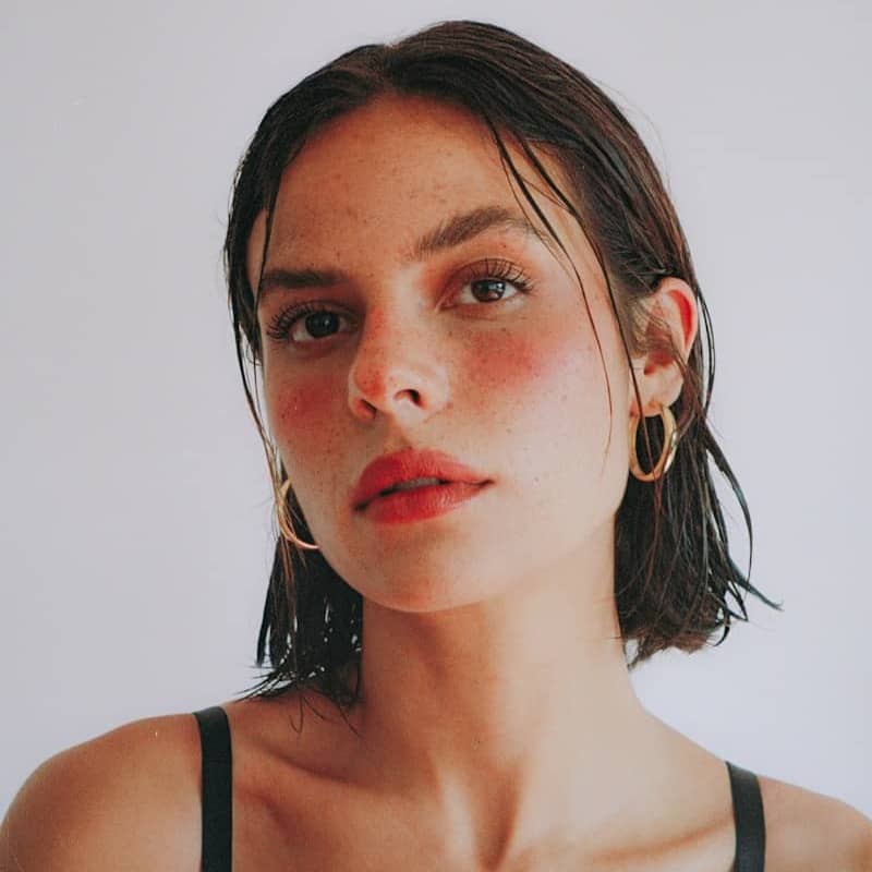 A woman in a black top is posing for a picture