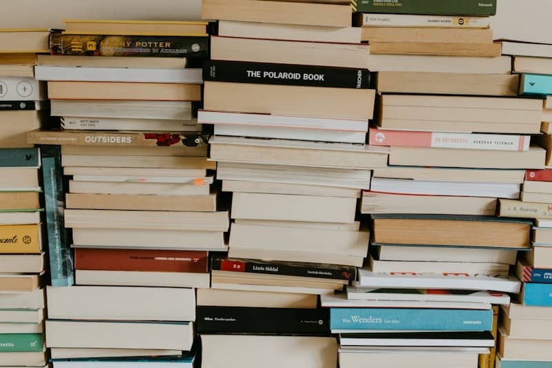 a pile of books sitting on top of a wall