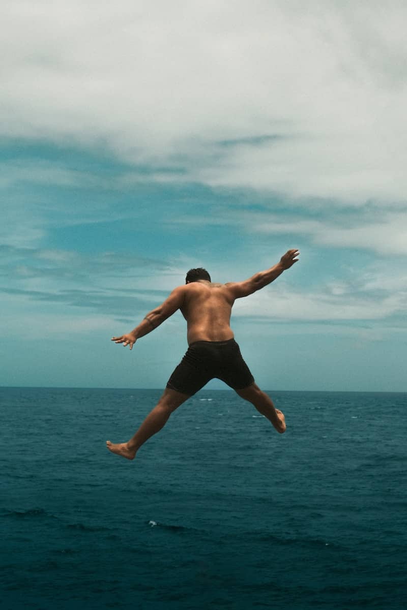 A man jumping into the air over the ocean