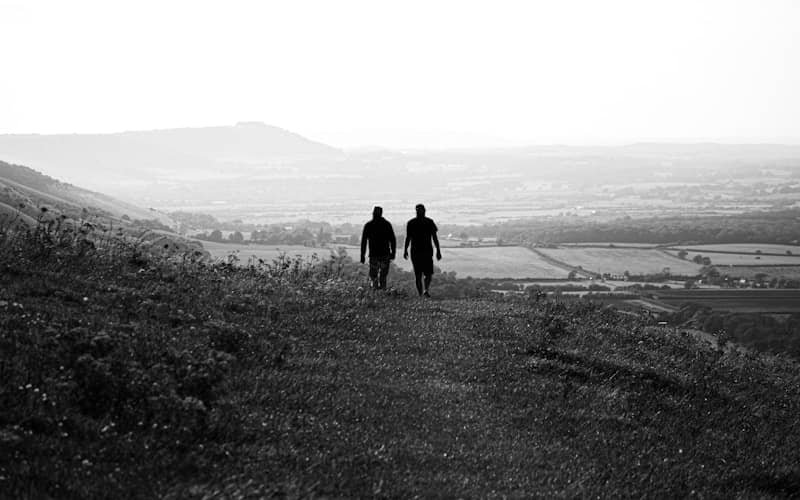 A couple of people that are walking down a hill