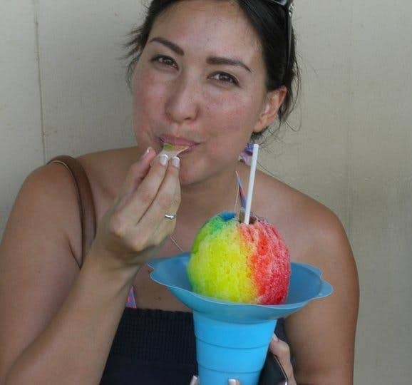 Malia Yoshioka  holds a multicolored shave ice cone on the north shore of Oahu, Hawaii 