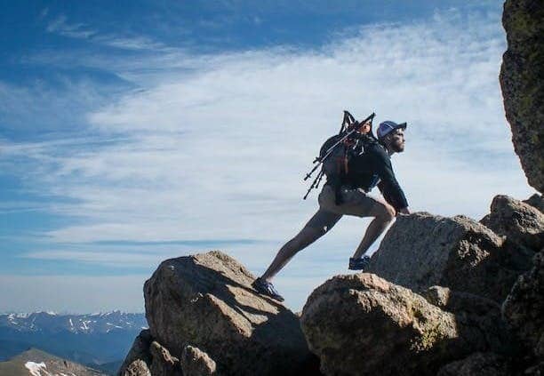 photo of man climbing mountain